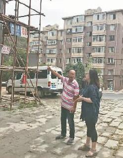 本報(bào)記者吳琳（右）采訪遼寧大連中山區(qū)“暖房子”工程現(xiàn)場(chǎng)負(fù)責(zé)人孫忠發(fā)。光明圖片